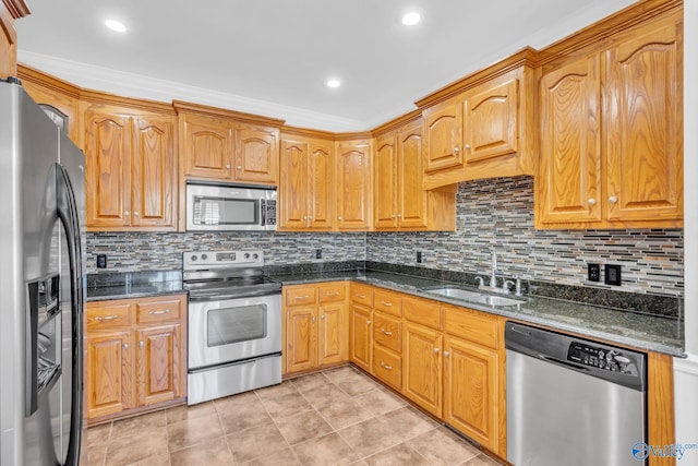 kitchen with sink, backsplash, stainless steel appliances, dark stone counters, and ornamental molding