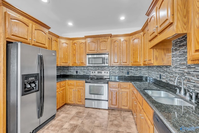 kitchen featuring tasteful backsplash, dark stone counters, ornamental molding, sink, and stainless steel appliances