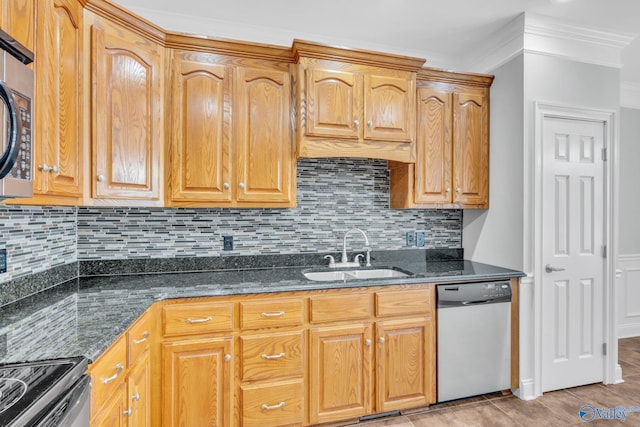 kitchen with tasteful backsplash, dark stone counters, sink, crown molding, and stainless steel appliances