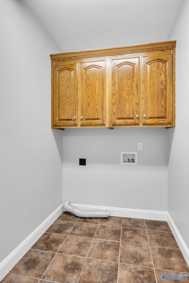 laundry room featuring dark tile patterned flooring, washer hookup, and cabinets