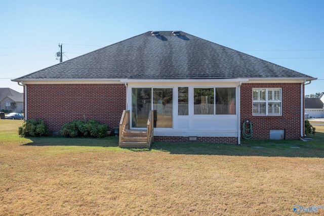 rear view of property featuring a yard and a sunroom