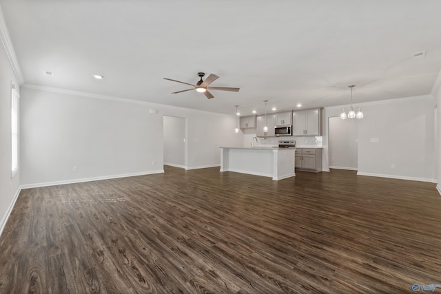 138 Barlow Way, Owens Cross Roads, AL 35763 - unfurnished living room with crown molding, baseboards, dark wood-style flooring, and ceiling fan with notable chandelier