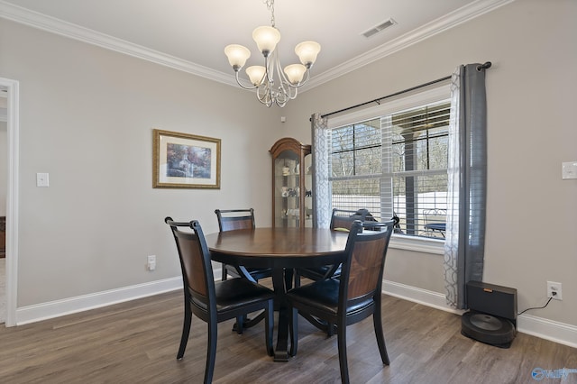 dining space featuring ornamental molding, dark hardwood / wood-style flooring, and a chandelier