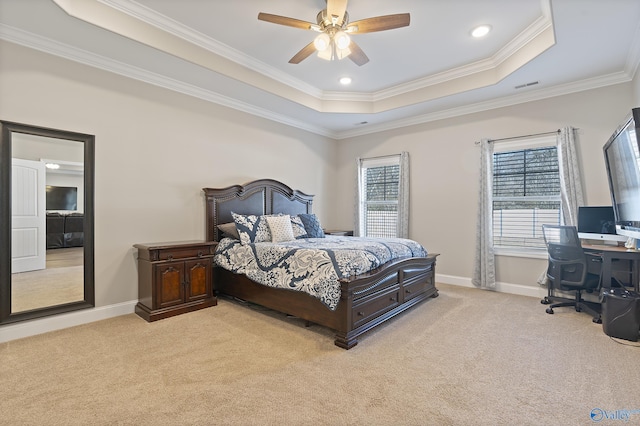 bedroom featuring multiple windows, a tray ceiling, ornamental molding, and light colored carpet