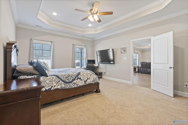 carpeted bedroom featuring ornamental molding, ceiling fan, and a tray ceiling