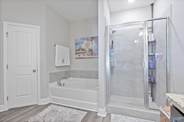 bathroom with hardwood / wood-style flooring and separate shower and tub