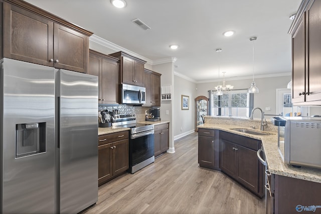 kitchen with dark brown cabinetry, sink, crown molding, decorative light fixtures, and appliances with stainless steel finishes