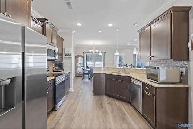 kitchen with pendant lighting, sink, stainless steel appliances, dark brown cabinetry, and ornamental molding