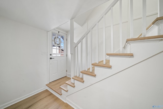 entrance foyer featuring stairs, baseboards, and wood finished floors