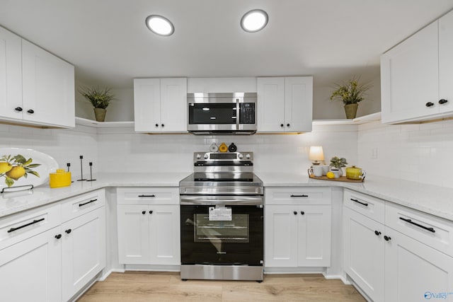 kitchen with white cabinetry, appliances with stainless steel finishes, decorative backsplash, open shelves, and light wood finished floors