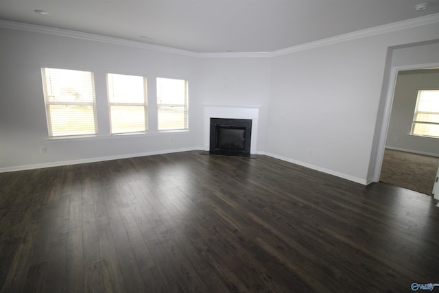 unfurnished living room with dark hardwood / wood-style flooring, ornamental molding, and a wealth of natural light