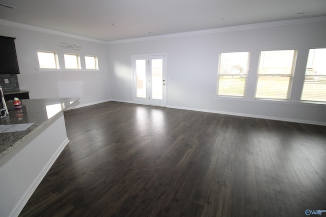 unfurnished living room with dark hardwood / wood-style flooring, plenty of natural light, and crown molding