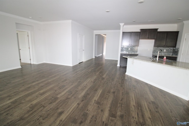 unfurnished living room with crown molding, sink, and dark wood-type flooring