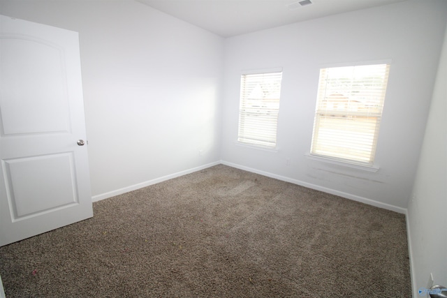 empty room featuring dark colored carpet