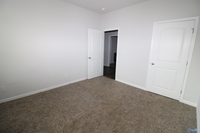 unfurnished bedroom with dark colored carpet