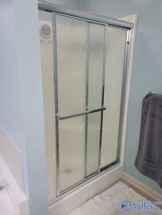 bathroom with a stall shower and baseboards