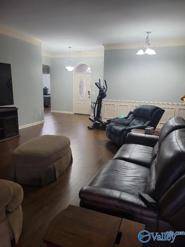 living room with a notable chandelier, crown molding, baseboards, and wood finished floors