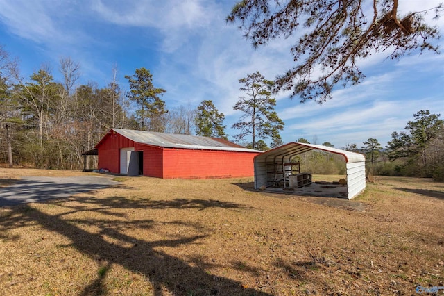 exterior space with an outdoor structure, a lawn, and a carport