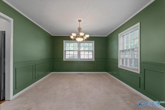 unfurnished room with crown molding, light colored carpet, plenty of natural light, and a notable chandelier