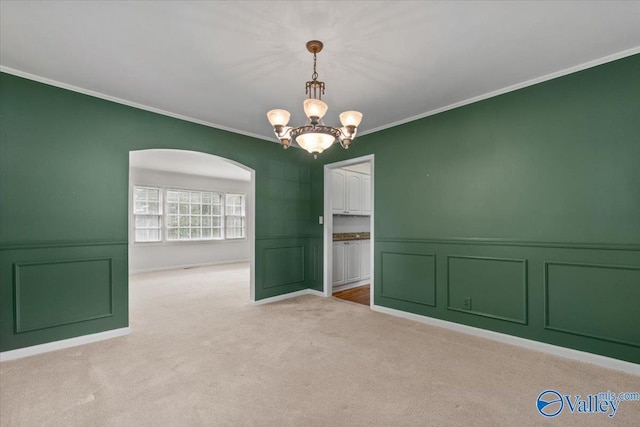 empty room featuring ornamental molding, light colored carpet, and an inviting chandelier