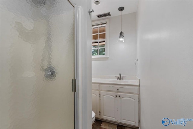 bathroom featuring vanity, toilet, and an enclosed shower