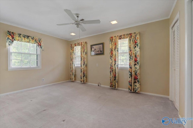 unfurnished bedroom with crown molding, light colored carpet, and ceiling fan