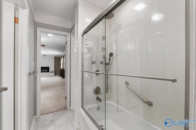 bathroom featuring crown molding and bath / shower combo with glass door