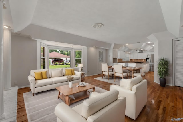 living room featuring vaulted ceiling and light wood-type flooring