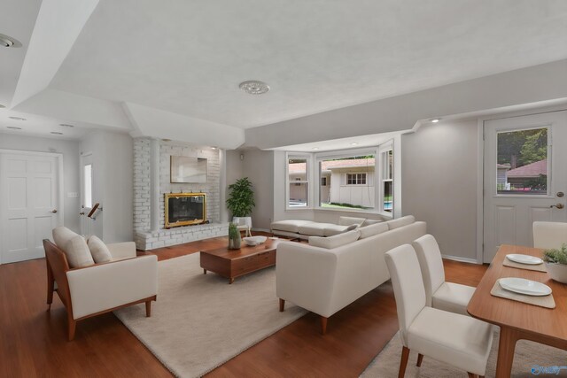 living room with a healthy amount of sunlight, a fireplace, and light wood-type flooring