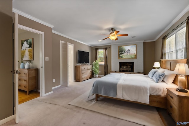 carpeted bedroom with a brick fireplace, ornamental molding, and ceiling fan