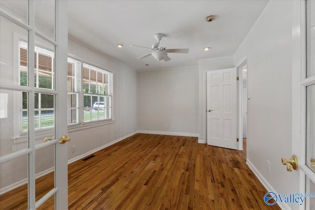 unfurnished room with crown molding, ceiling fan, and dark wood-type flooring