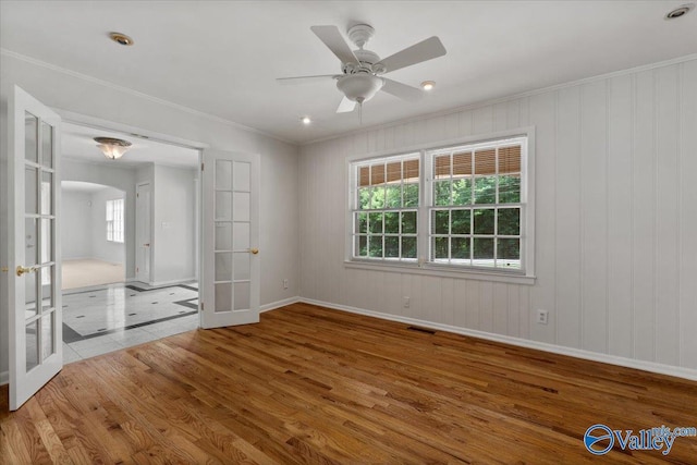 unfurnished bedroom with french doors, multiple windows, and hardwood / wood-style flooring