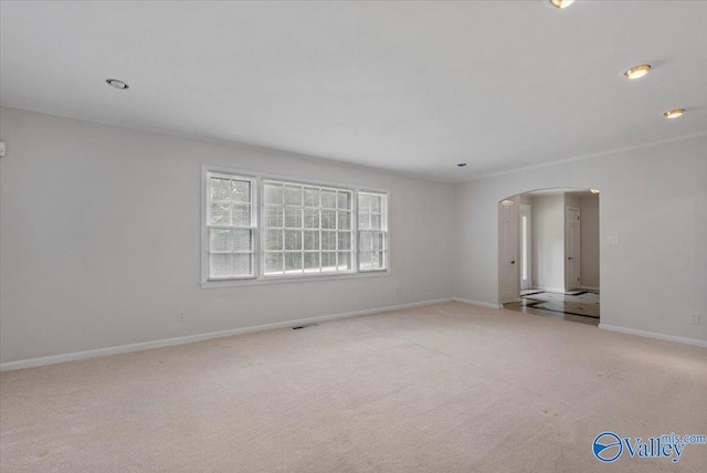 carpeted spare room featuring crown molding