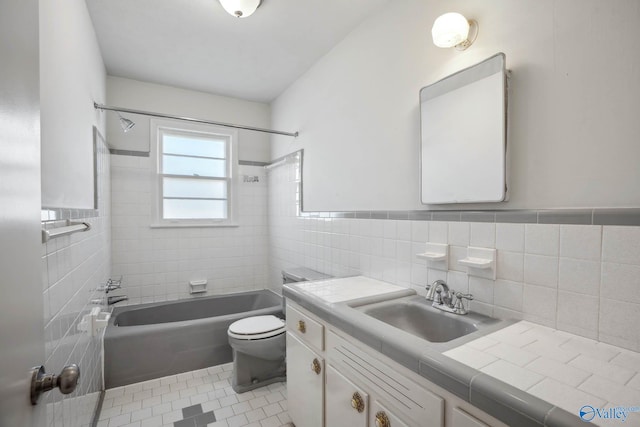 full bathroom featuring shower / bath combination, toilet, tile patterned flooring, vanity, and tile walls