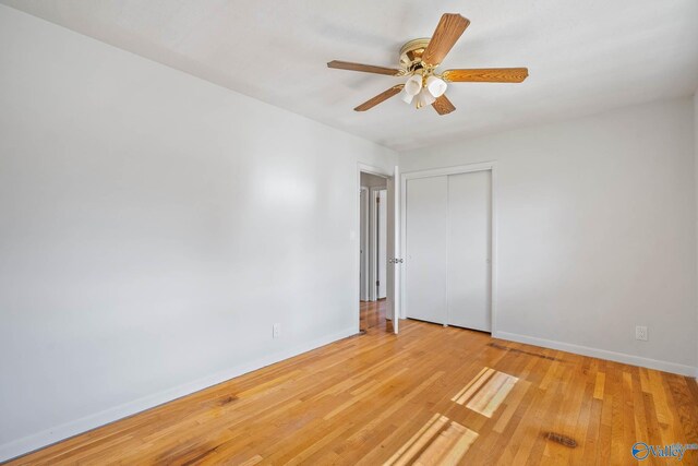 spare room with a ceiling fan, light wood-style flooring, and baseboards