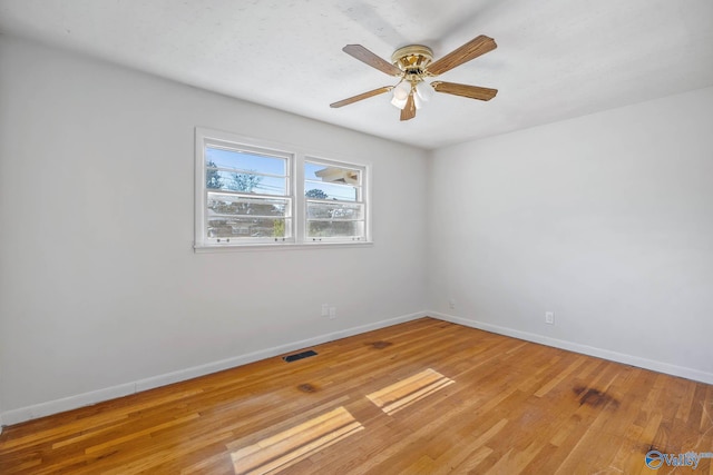 unfurnished room with light wood-style flooring, visible vents, and baseboards