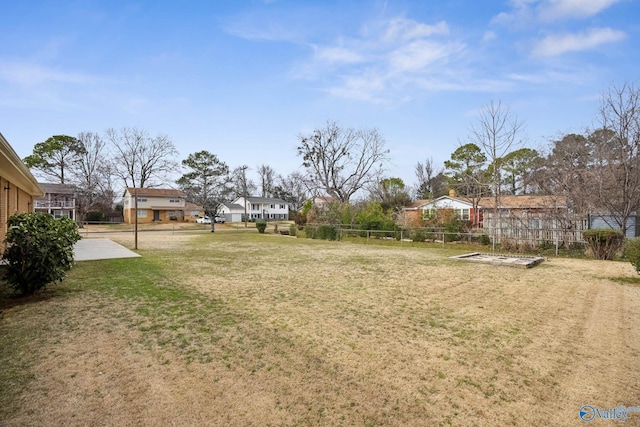 view of yard featuring a garden, a residential view, and fence