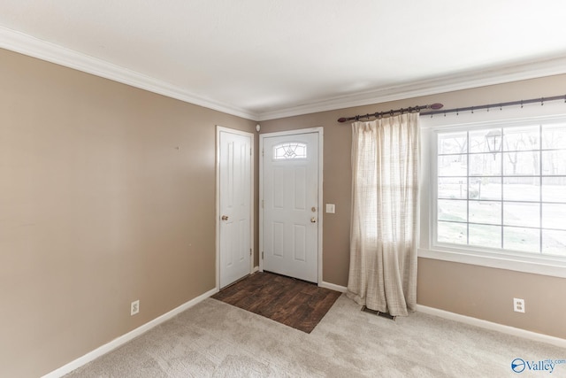 carpeted entryway featuring baseboards, visible vents, and ornamental molding