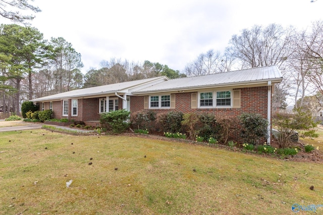 single story home with metal roof, brick siding, and a front yard