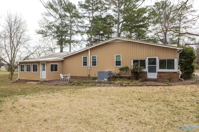 rear view of property featuring a patio, a lawn, and central AC unit