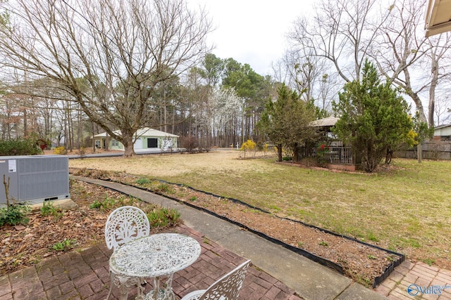 view of yard with central AC and fence