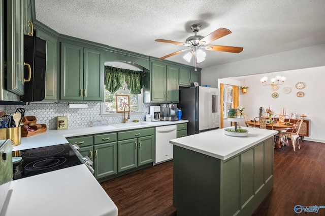 kitchen with dark wood-style floors, freestanding refrigerator, a sink, dishwasher, and green cabinets