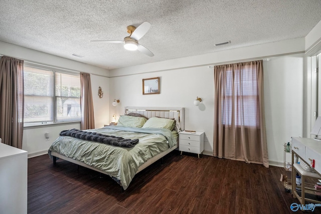 bedroom featuring baseboards, wood finished floors, visible vents, and ceiling fan