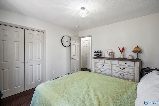 bedroom with a closet, a textured ceiling, and dark wood-style flooring