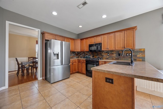 kitchen featuring light tile patterned flooring, sink, kitchen peninsula, decorative backsplash, and black appliances