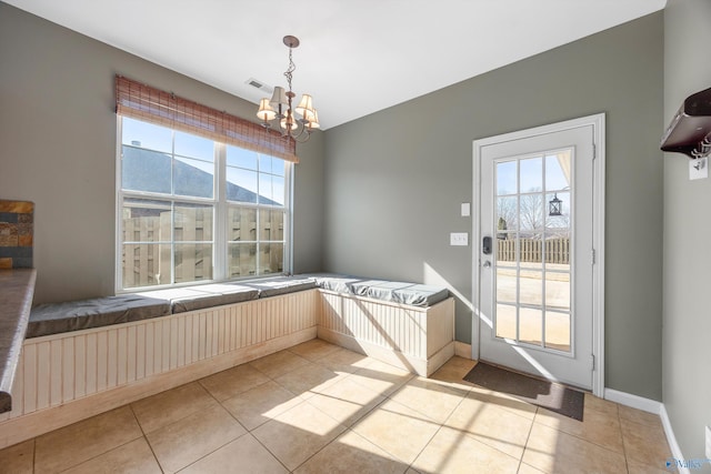 interior space with light tile patterned flooring, a mountain view, and a chandelier