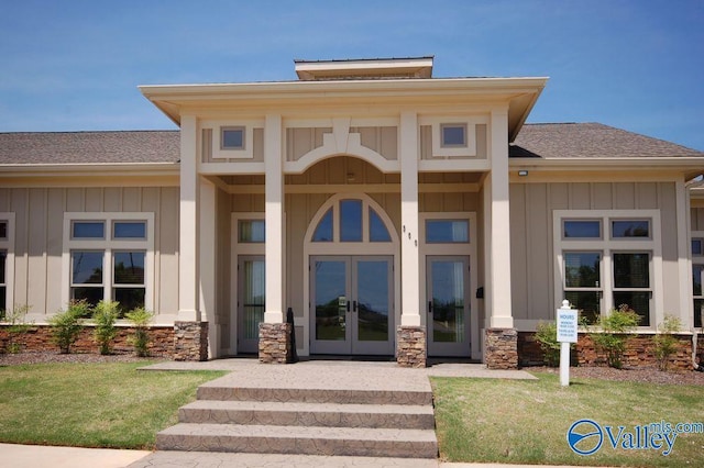 view of exterior entry with french doors and a yard