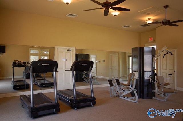 exercise room featuring a towering ceiling, ceiling fan, and carpet flooring