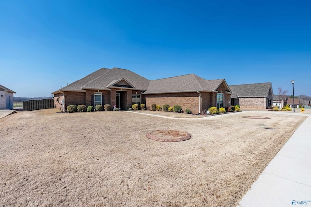 view of front of home with brick siding and a shingled roof