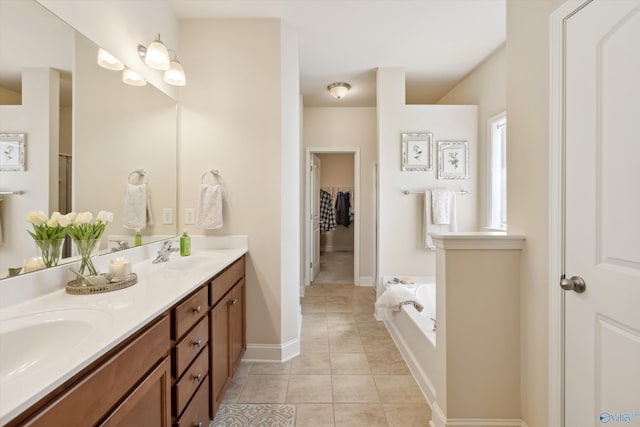 full bath featuring tile patterned floors, double vanity, a garden tub, and a sink